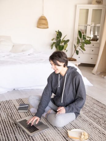 Woman taking a video call on the floor.